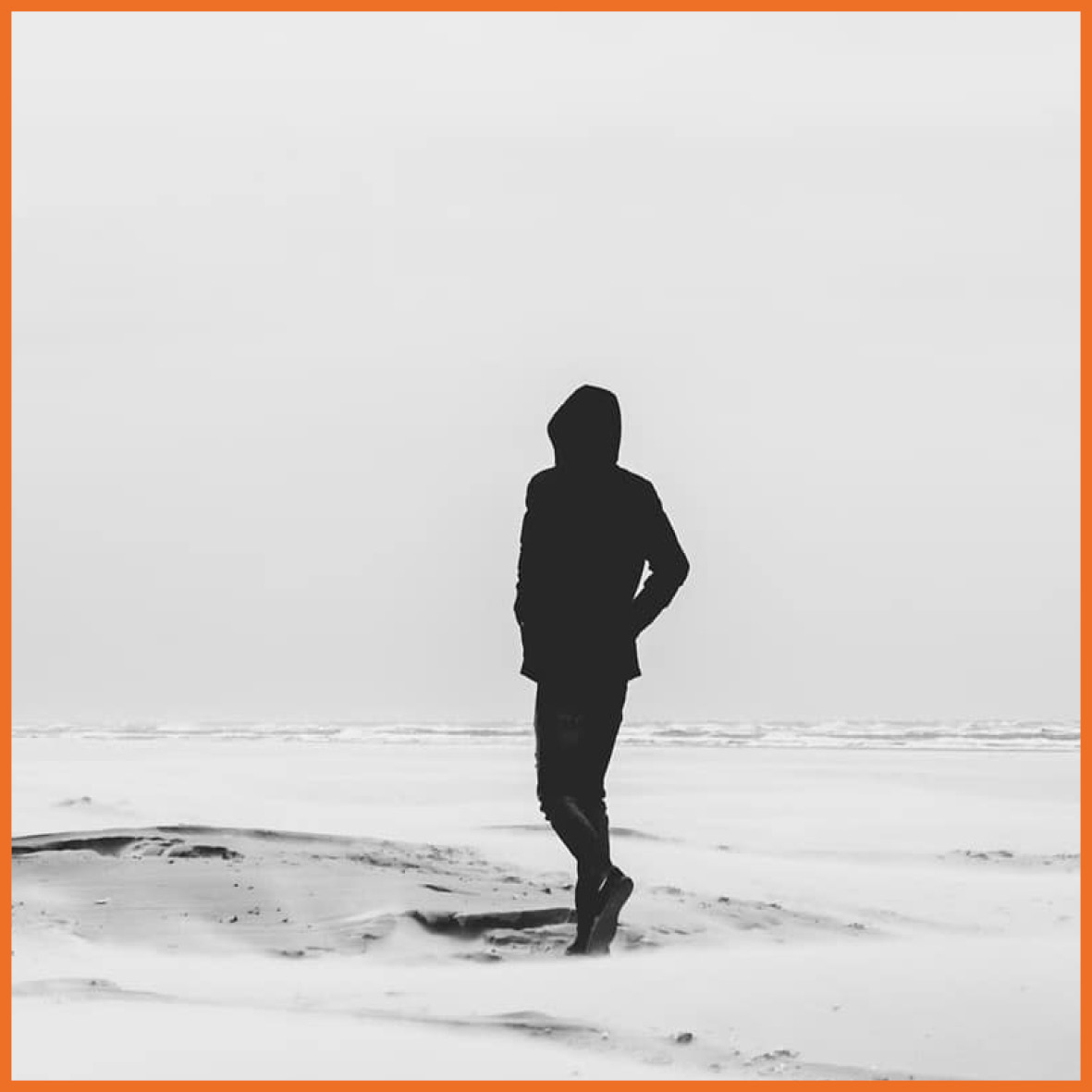 Billede af en person der går alene på stranden.