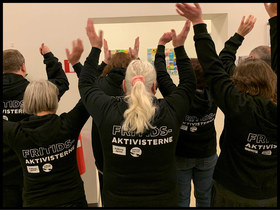 Billede af personer der står med ryggen til iført trøjer hvorpå der står FRI-TIDsaktivisterne.